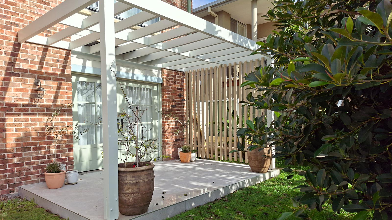 Fingal Bay upper terrace after the tiled outdoor area, pergola and privacy screen were added