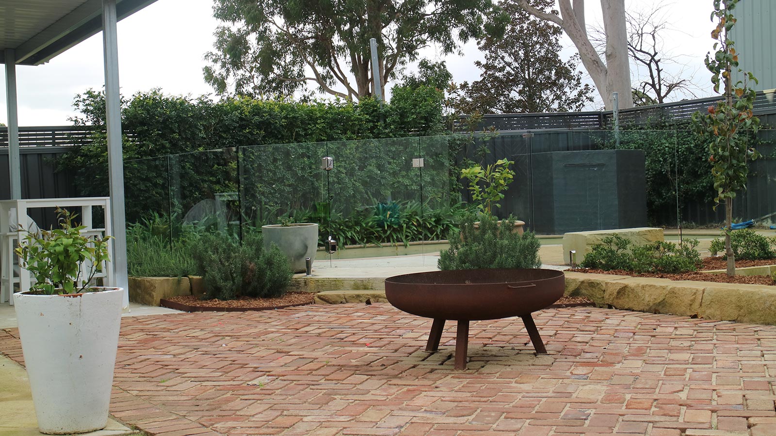 Medowie backyard after the lawn, brick paving, sandstone edging and pool landscaping were completed